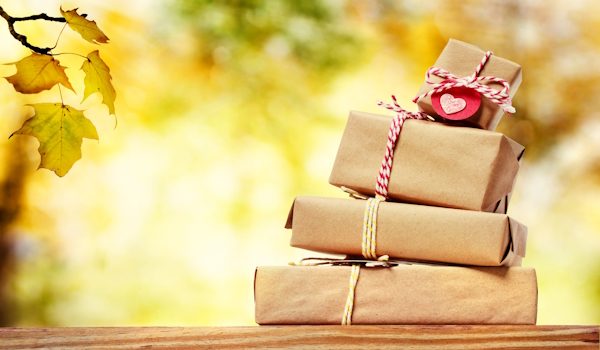 Stack of gift boxes with an autumn sky and foliage background